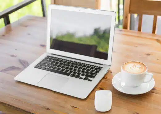 Laptop With Coffee Cup On Old Wooden Table