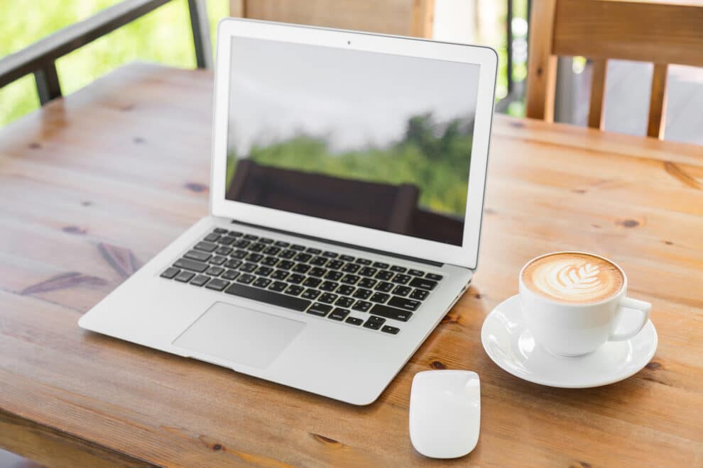 Laptop With Coffee Cup On Old Wooden Table